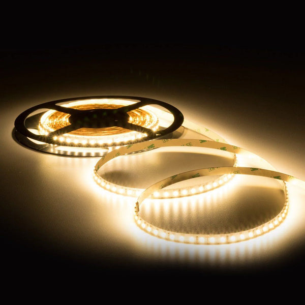 Warm white 24V SMD LED strip reel, lit, on a black background