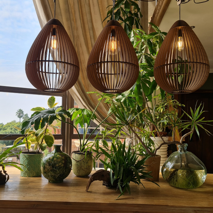 Honey Badger Aqua Tear-Drop Pendant Light – trio of pendants above a table with indoor plants