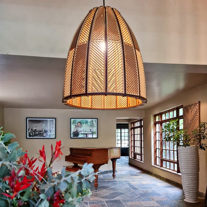 Honey Badger Burundi Panel Basket Pendant Light – lit pendant in a living room with a piano