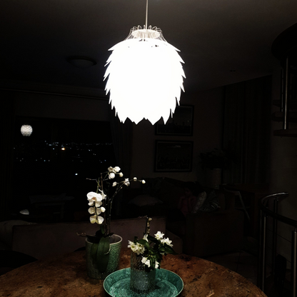 Honey Badger Pinopoly Pendant Light – lit frosted white pendant above a dining table at night