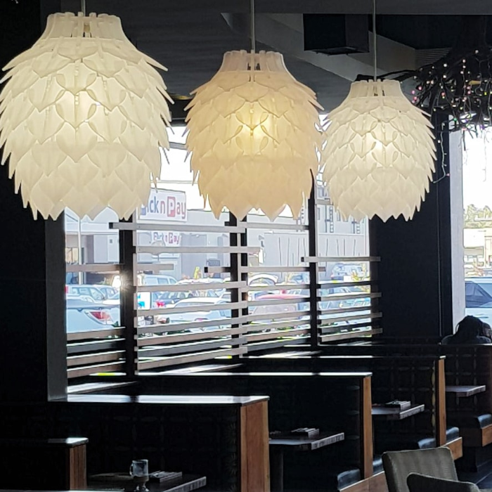 Honey Badger Pinopoly Pendant Light – lit frosted white pendants in a restaurant