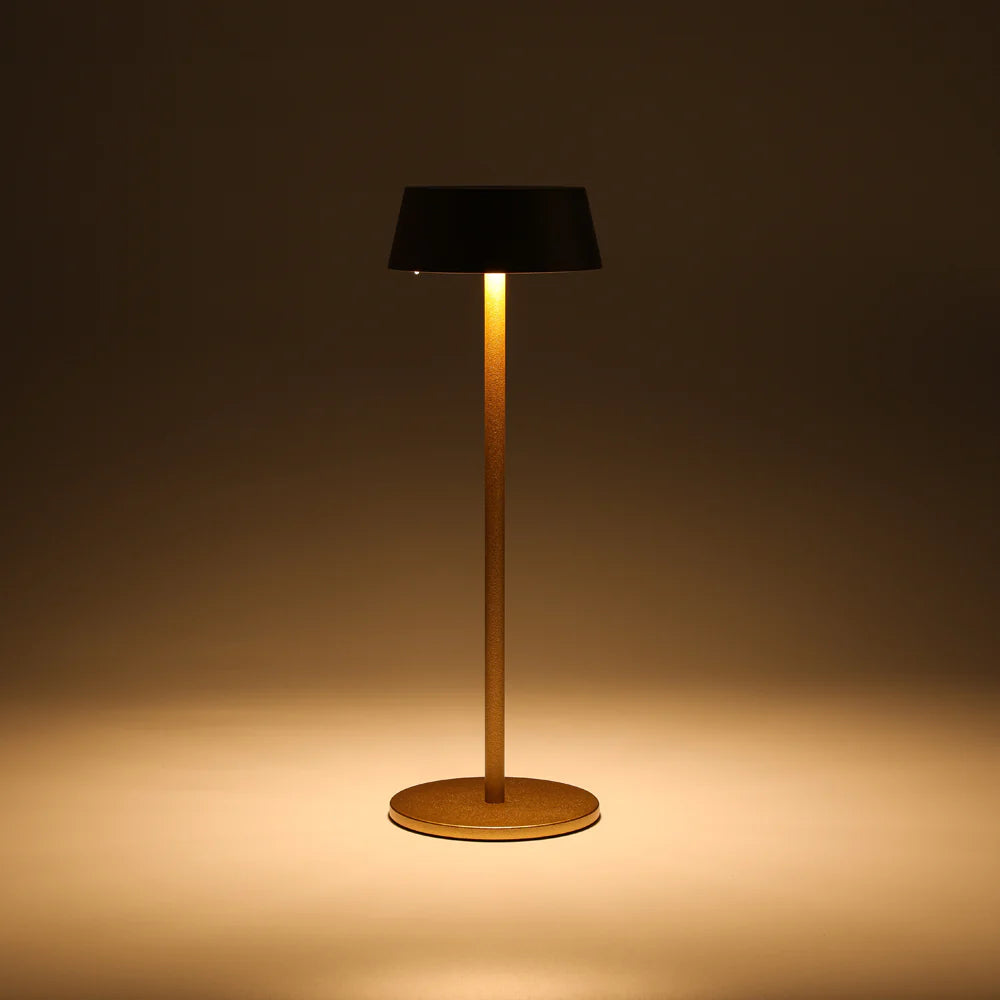 SPAZIO Lola Pro Rechargeable Cordless Table Lamp – lit lamp with a dark shade and gold stem, casting a warm glow