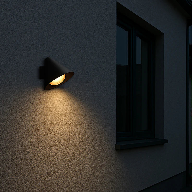 SPAZIO Railroad 1 Outdoor Wall Light – lit on an outdoor wall at night