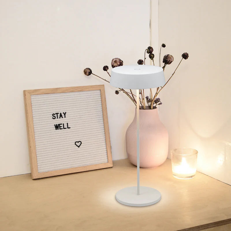 SPAZIO Slender Rechargeable Table Lamp – lamp on a side table beside a vase and letter board