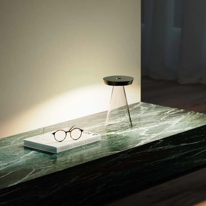 SPAZIO Torus Glass Rechargeable Desk Lamp – lit lamp on a marble table beside glasses