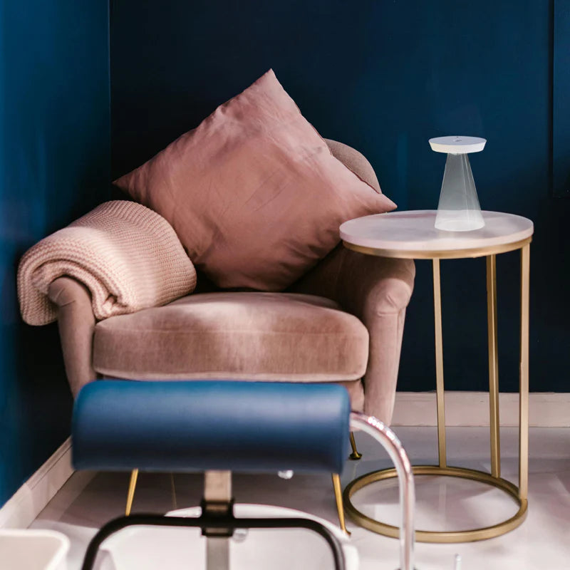 SPAZIO Torus Glass Rechargeable Desk Lamp – lamp on a side table beside an armchair