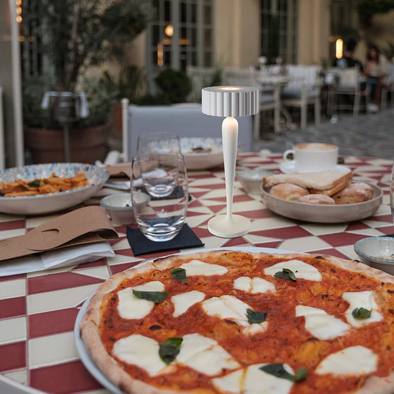 SPAZIO Twiggy Rechargeable Table Lamp – lamp on an outdoor restaurant table with pizza