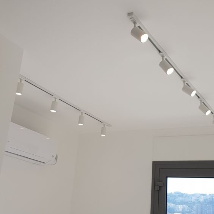 Synerji 4-Light Aluminium Track Spotlight – white spotlights on a ceiling track in a room